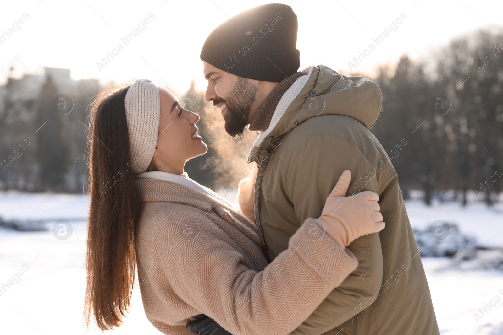 Photo of Beautiful happy couple in snowy park on winter day