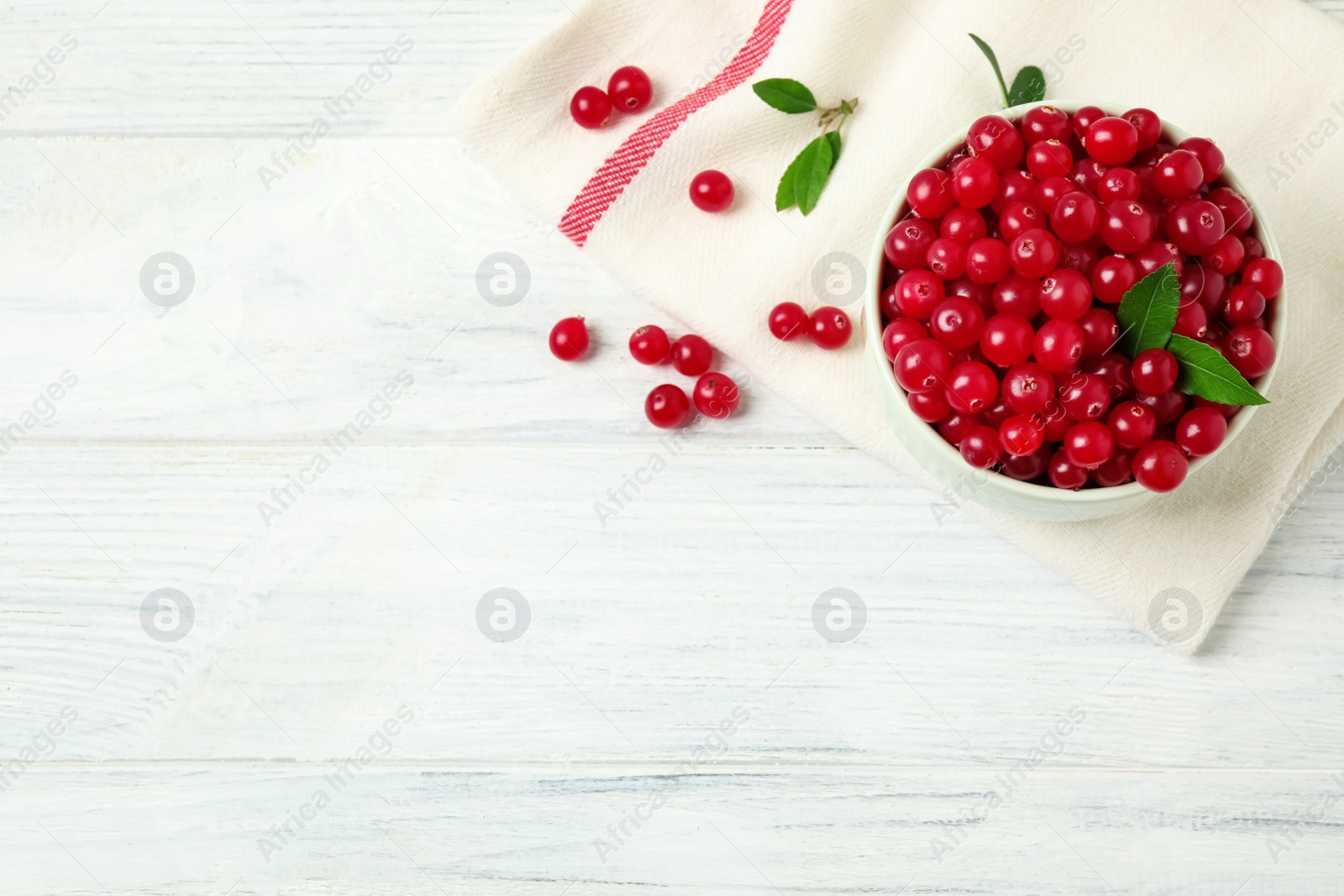 Photo of Tasty ripe cranberries on white wooden table, flat lay. Space for text