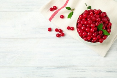 Photo of Tasty ripe cranberries on white wooden table, flat lay. Space for text