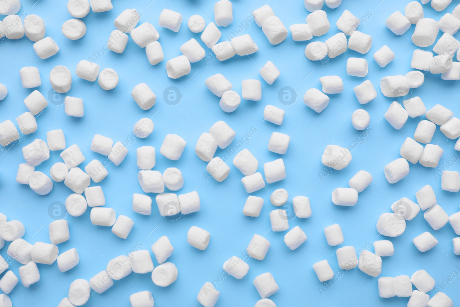 Photo of Delicious marshmallows on light blue background, flat lay