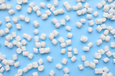 Photo of Delicious marshmallows on light blue background, flat lay