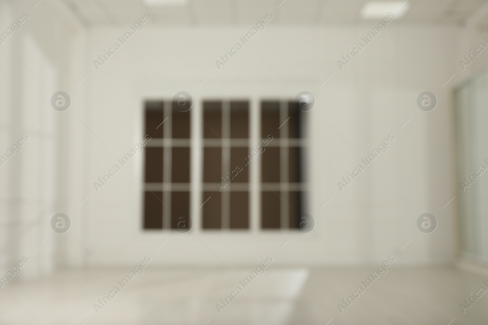 Photo of Empty room with white walls and large window, blurred view