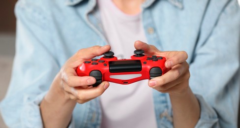 Photo of Woman playing video game with controller, closeup