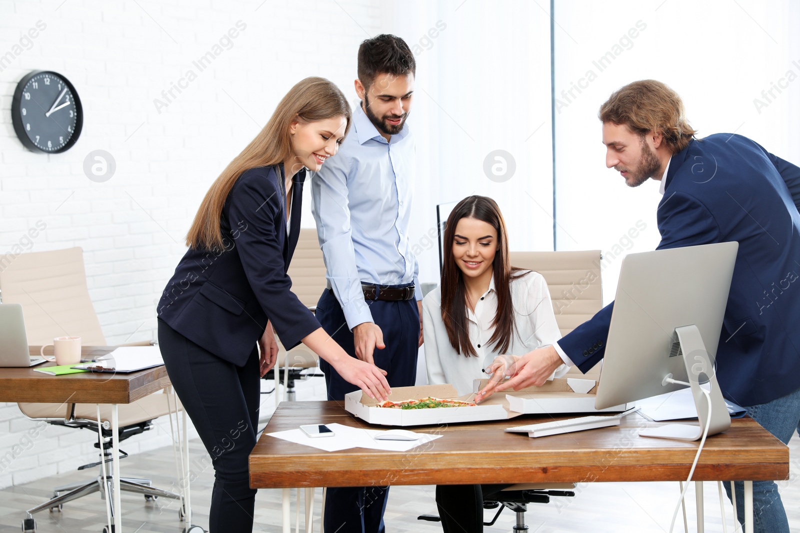 Photo of Office employees having pizza for lunch at workplace. Food delivery