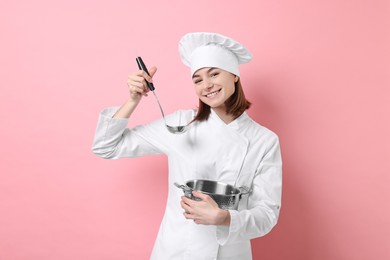 Photo of Professional chef cooking pot and ladle on pink background