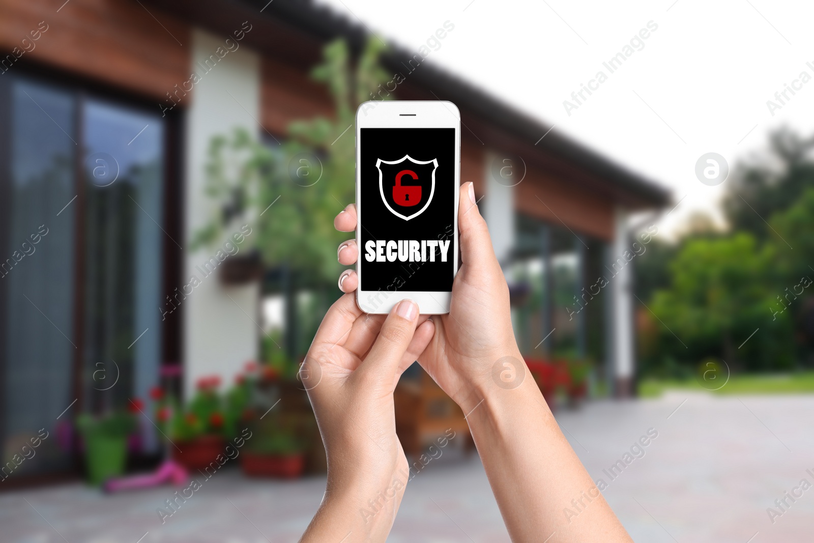 Image of Alarm system. Woman using phone outdoors, closeup