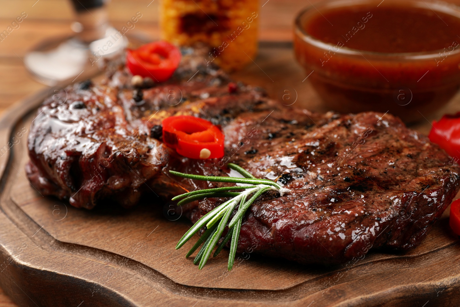 Photo of Delicious fried steak and sauce on wooden table, closeup