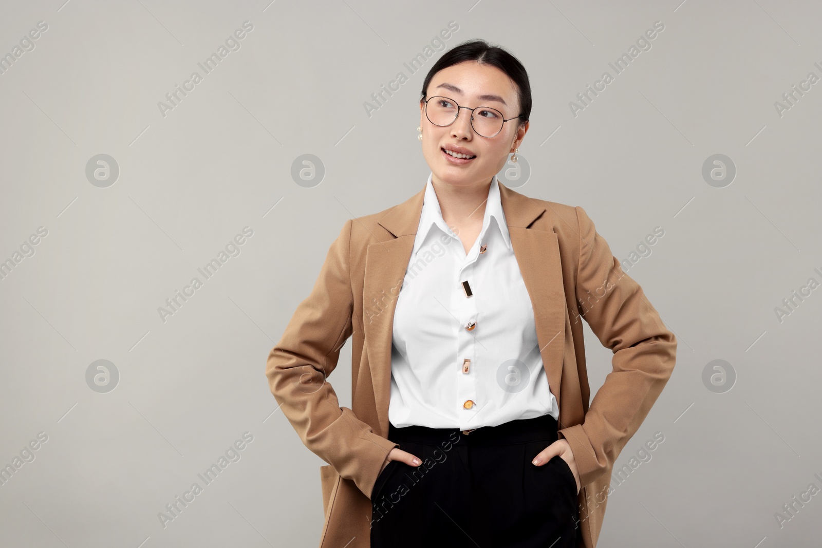 Photo of Portrait of smiling businesswoman on grey background. Space for text