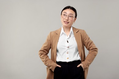 Portrait of smiling businesswoman on grey background. Space for text