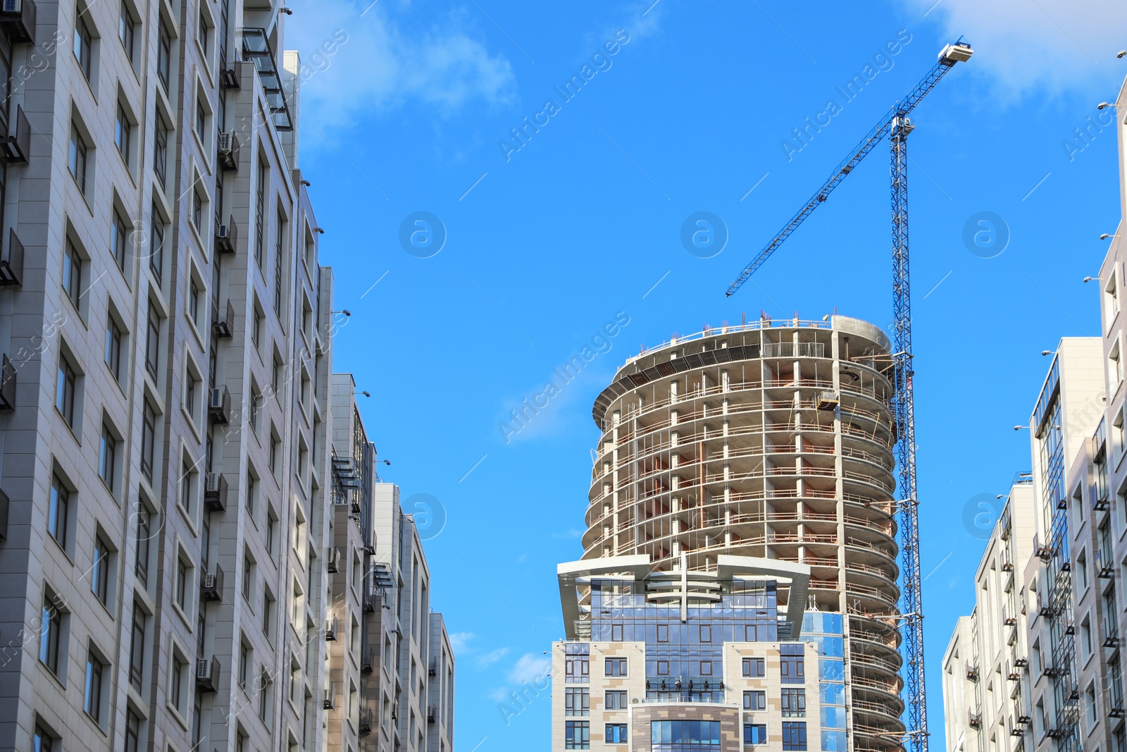 Photo of Unfinished building against blue sky. Construction safety rules