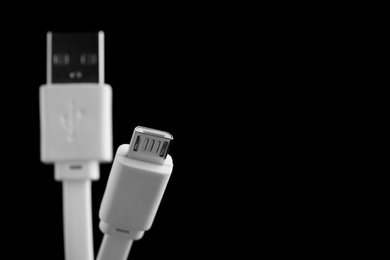 Photo of Charge cables on black background, closeup. Space for text