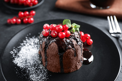 Delicious warm chocolate lava cake with mint and berries on table, closeup