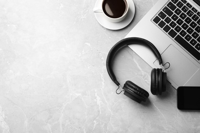 Flat lay composition with headphones and laptop on table. Space for text