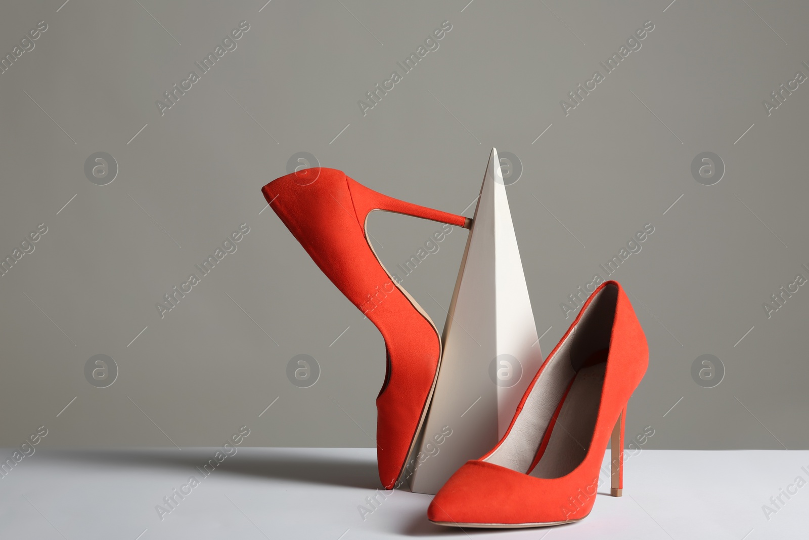 Photo of Composition with elegant female shoes on table against grey background