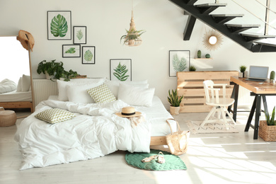 Photo of Elegant interior of bedroom with workplace under stairs