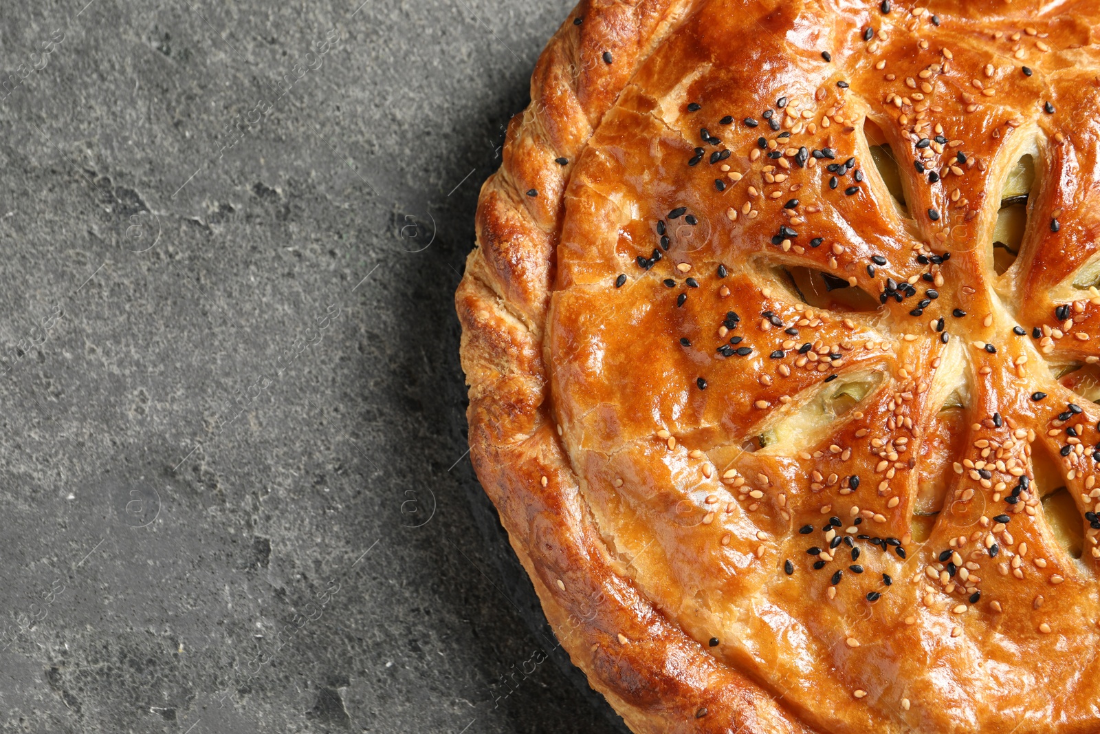 Photo of Tasty homemade pie with filling on grey table, top view. Space for text