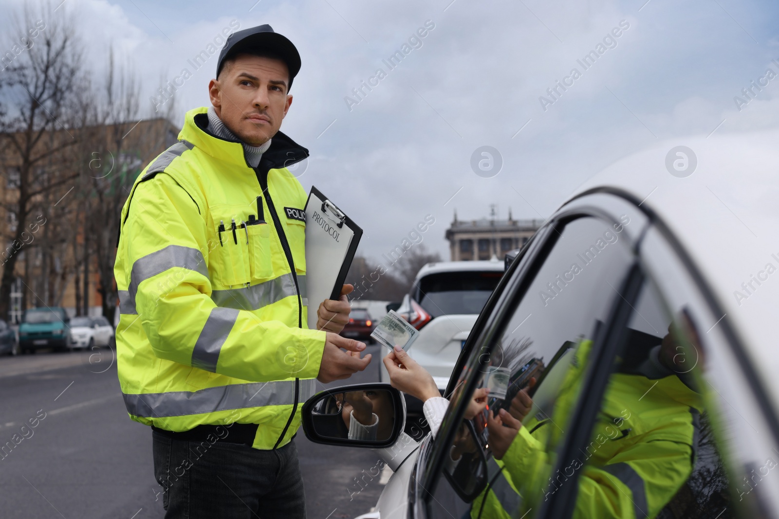 Photo of Woman giving bribe to police officer out of car window