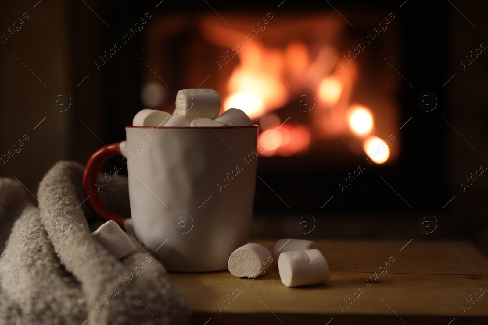 Photo of Tasty drink with marshmallows in cup on wooden table, closeup. Space for text