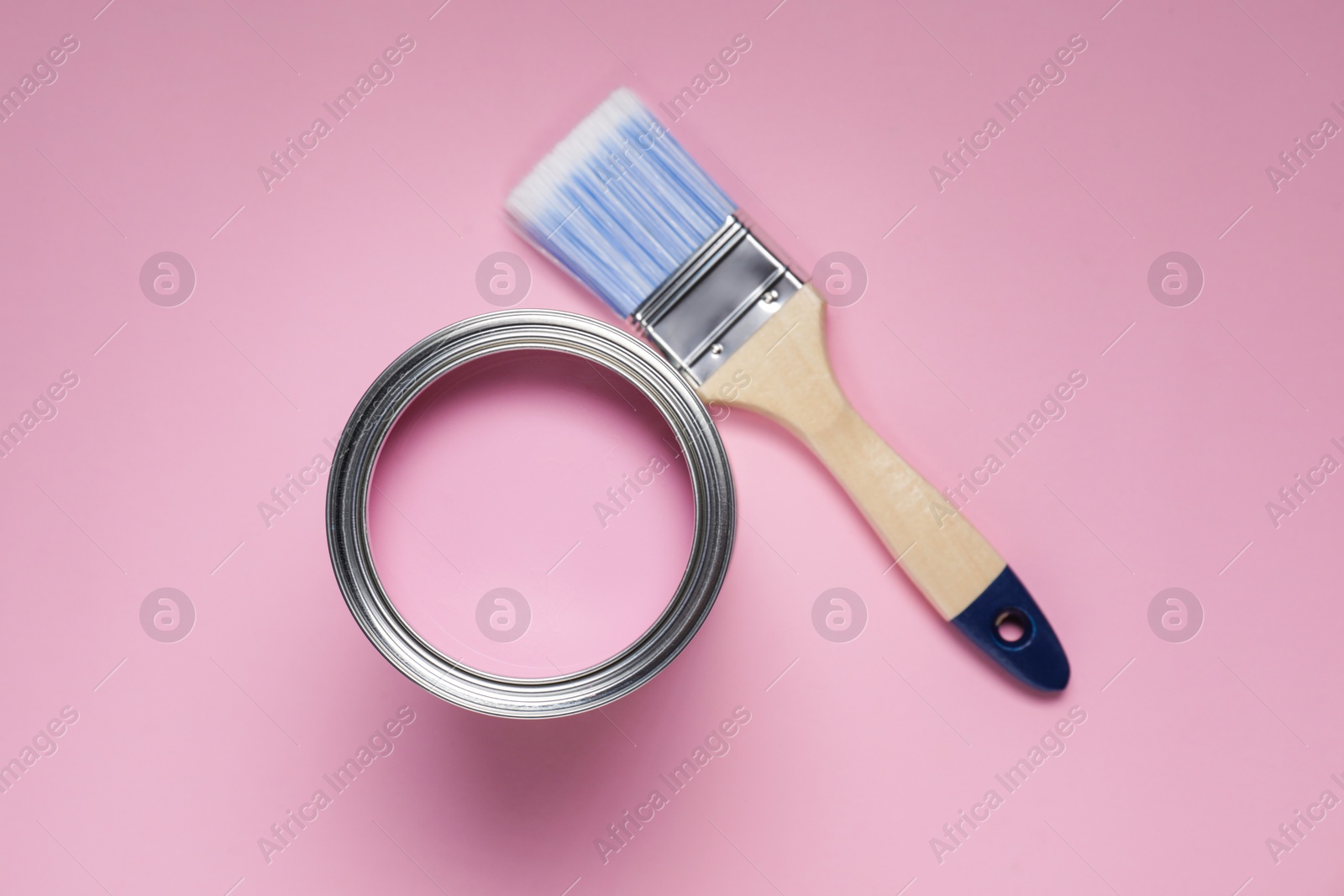 Photo of Can with paint and brush on pink background, flat lay