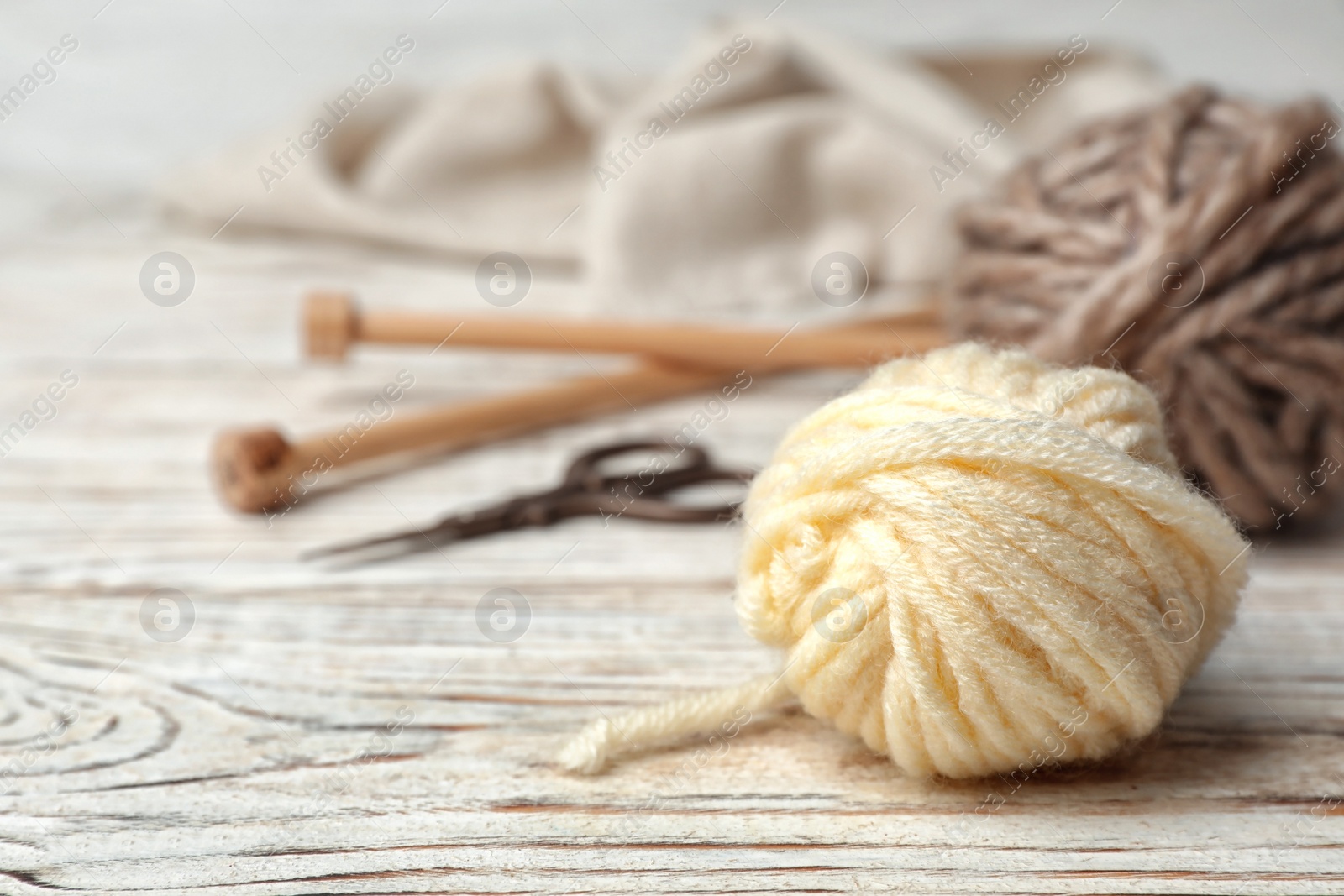 Photo of Composition with threads and knitting accessories on wooden background