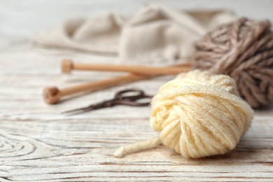 Photo of Composition with threads and knitting accessories on wooden background