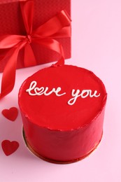 Photo of Bento cake with text Love You, gift box and paper hearts on pink table. St. Valentine's day surprise