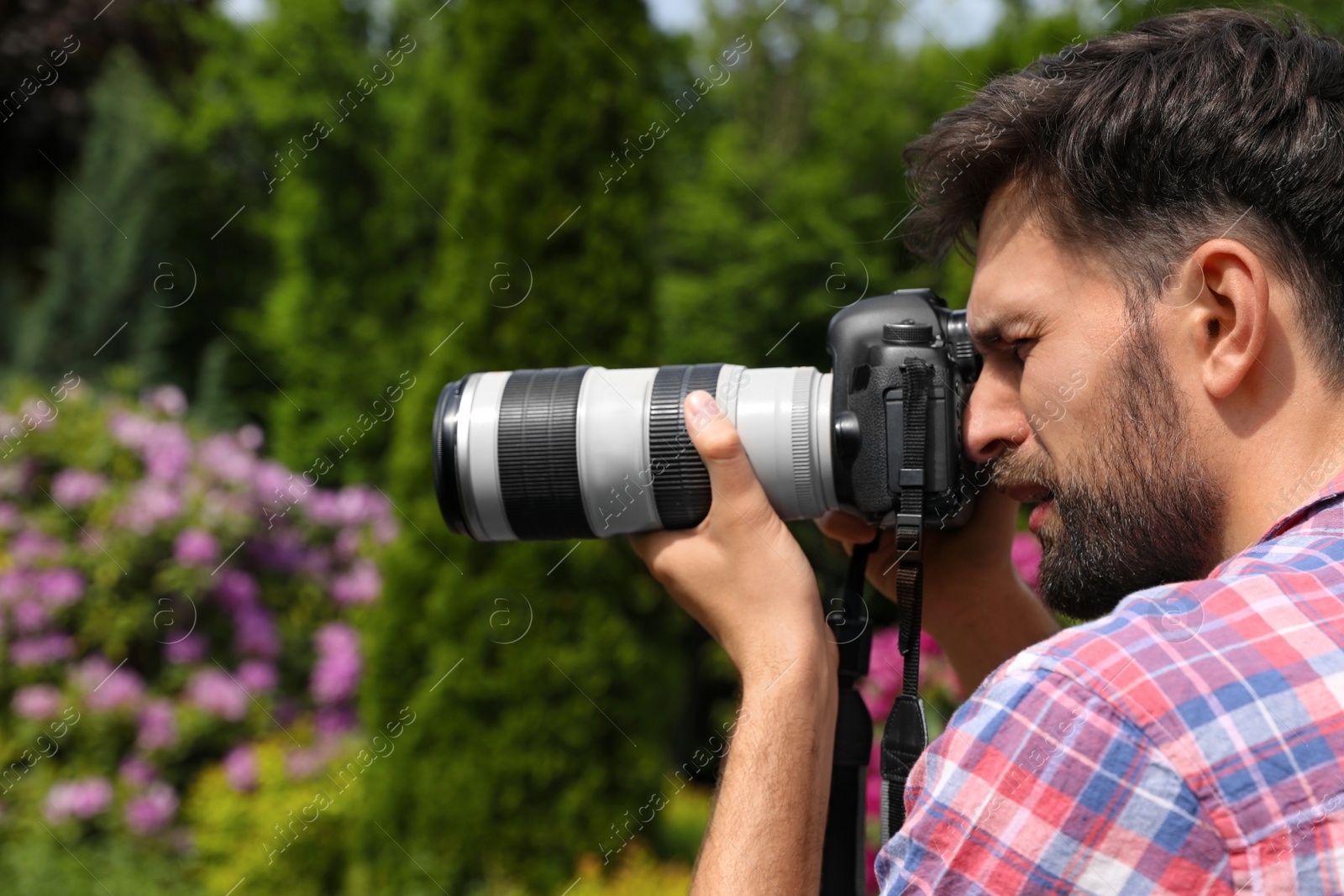 Photo of Photographer taking photo with professional camera in park