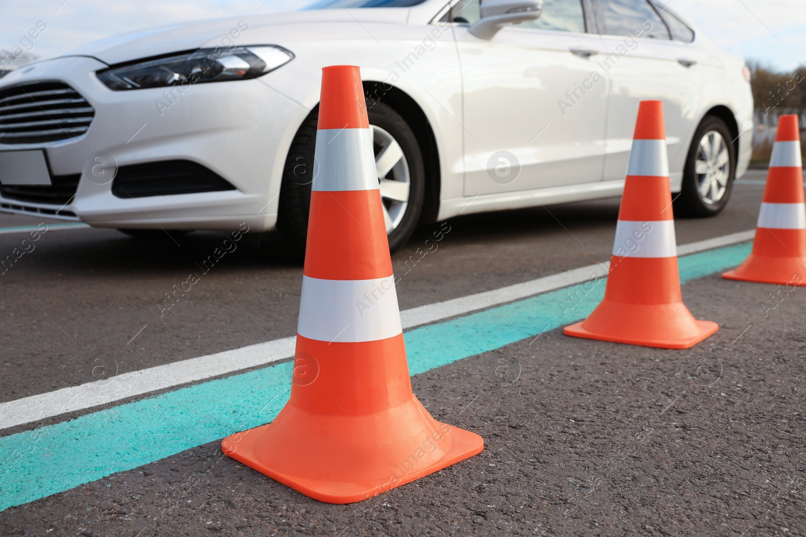 Photo of Modern car at test track, focus on traffic cone. Driving school