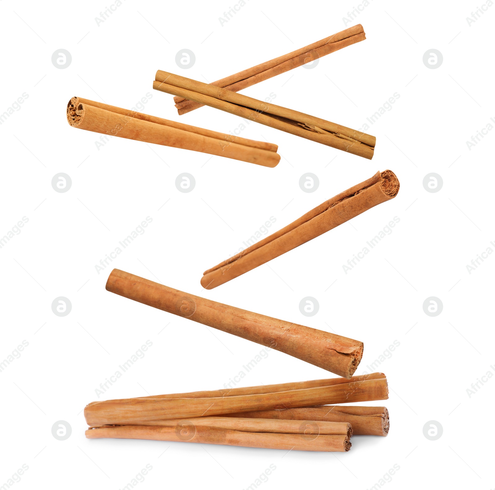 Image of Aromatic cinnamon sticks falling on white background 