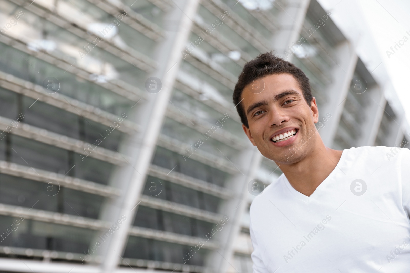 Photo of Portrait of handsome young African-American man on city street. Space for text