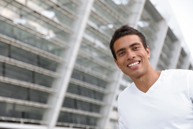 Photo of Portrait of handsome young African-American man on city street. Space for text