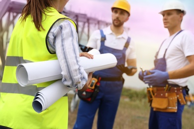 Professional engineers working on installation of electrical substation outdoors