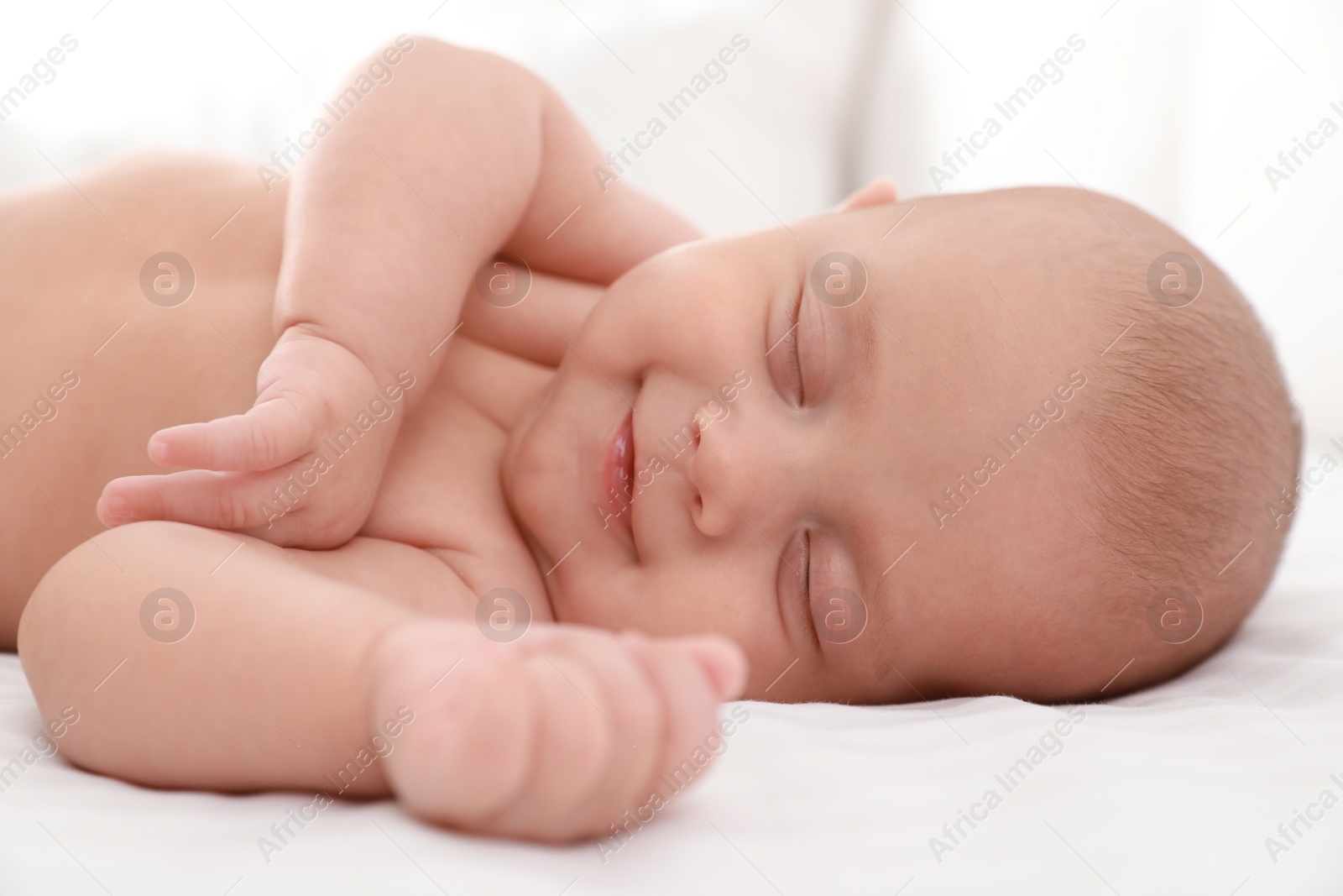 Photo of Cute little baby sleeping on bed, closeup