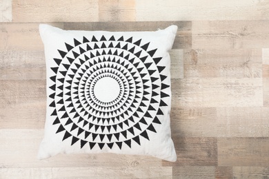 Soft decorative pillow on wooden background, top view