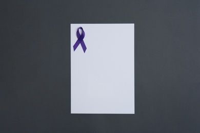 Photo of Purple awareness ribbon and blank card on black background, top view with space for text