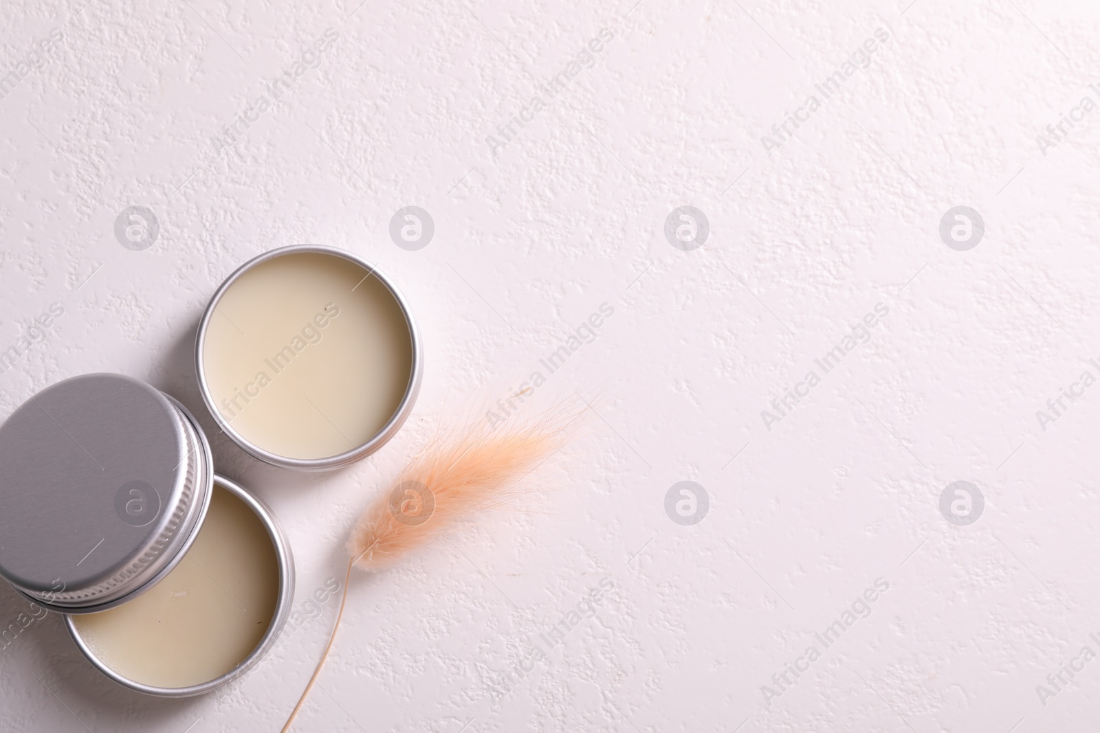 Photo of Lip balms and spikes on white table, flat lay. Space for text