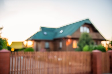 Photo of Blurred view of beautiful house behind fence