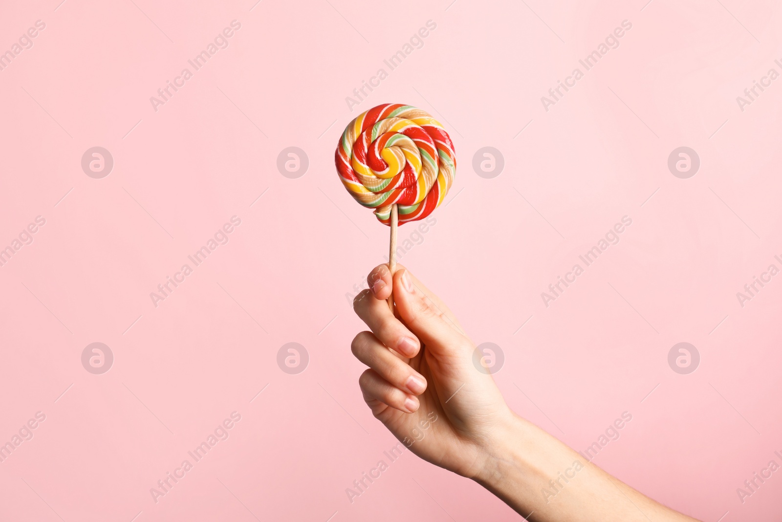 Photo of Woman holding yummy candy on color background