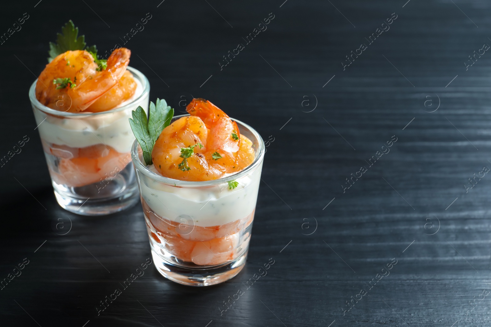 Photo of Glasses with fried shrimps and sauce on wooden background