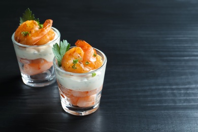 Photo of Glasses with fried shrimps and sauce on wooden background