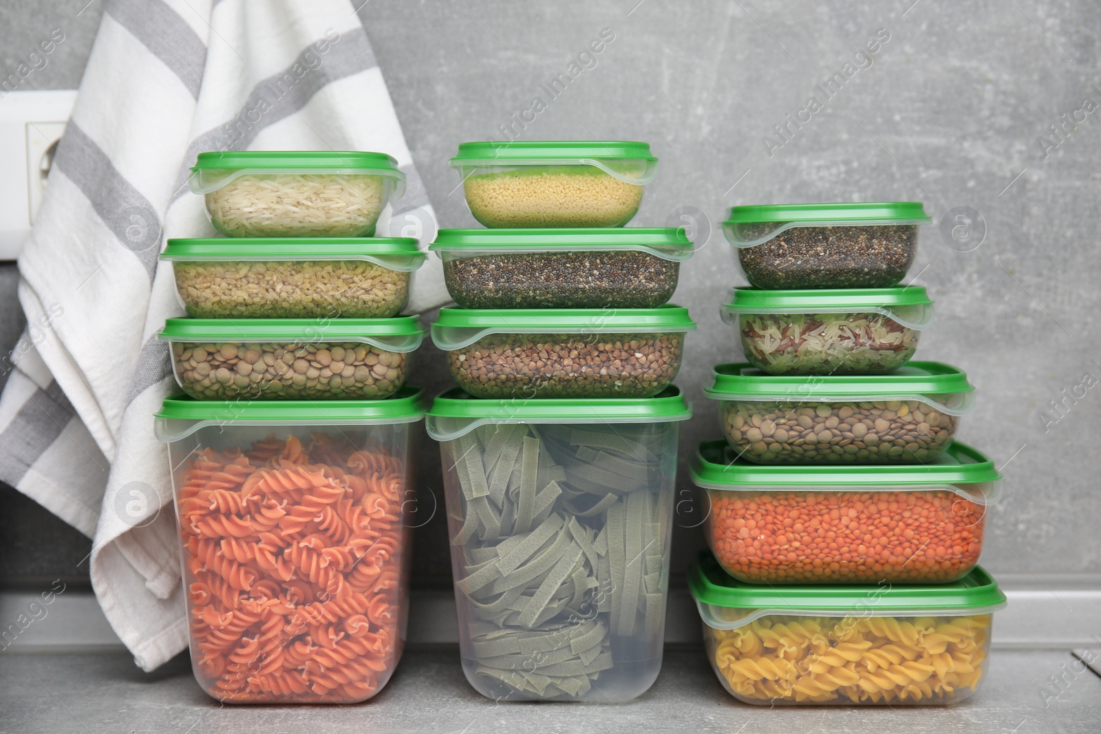 Photo of Plastic containers filled with food products on grey table