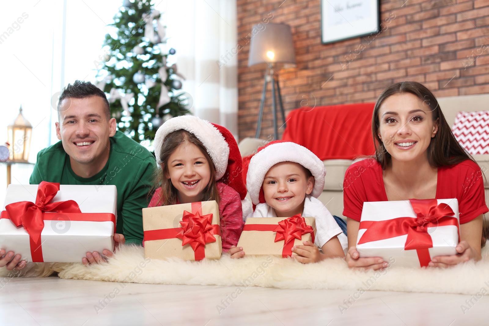 Photo of Happy parents and children with gifts near Christmas tree at home