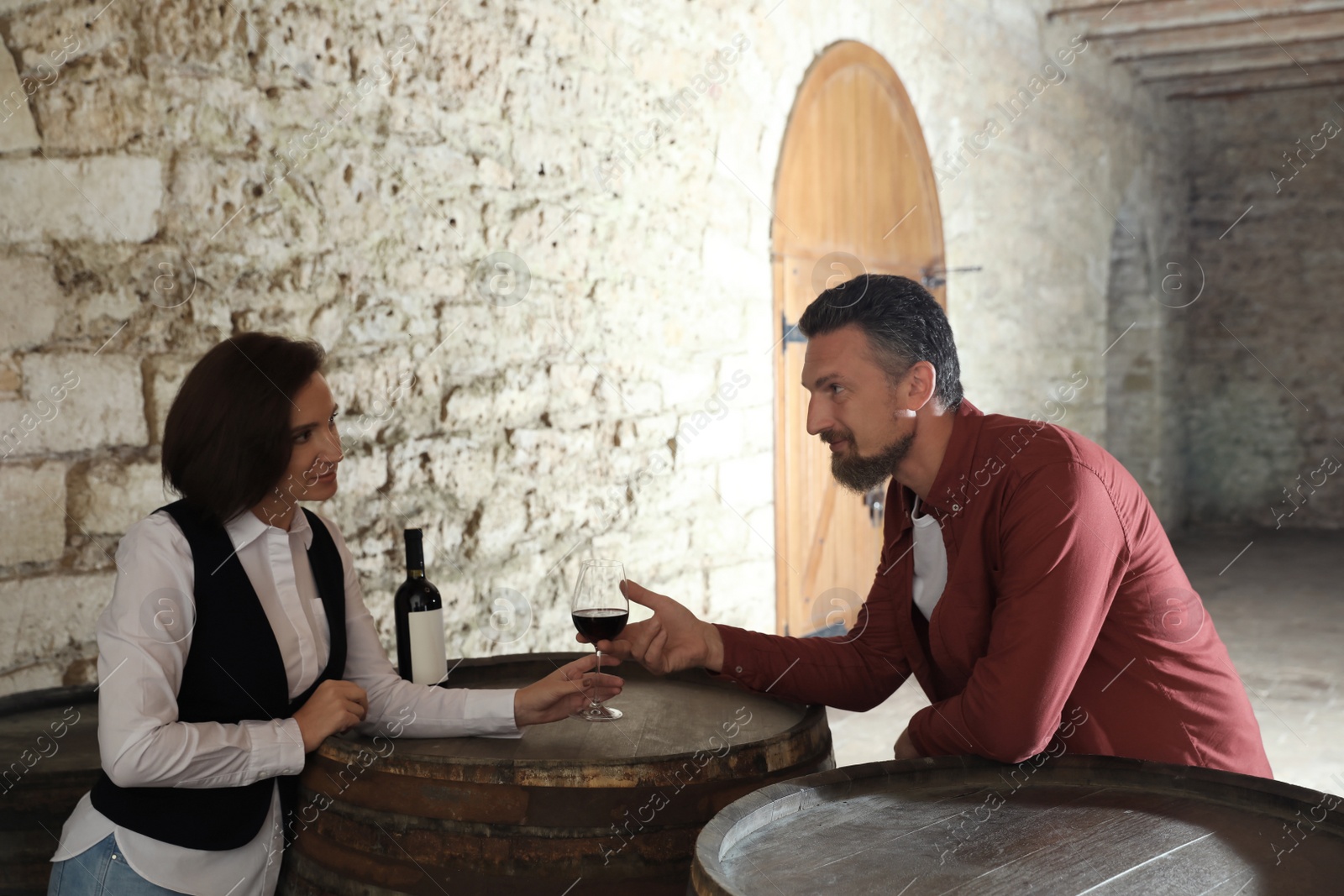 Photo of Waitress serving glass of red wine to client in restaurant