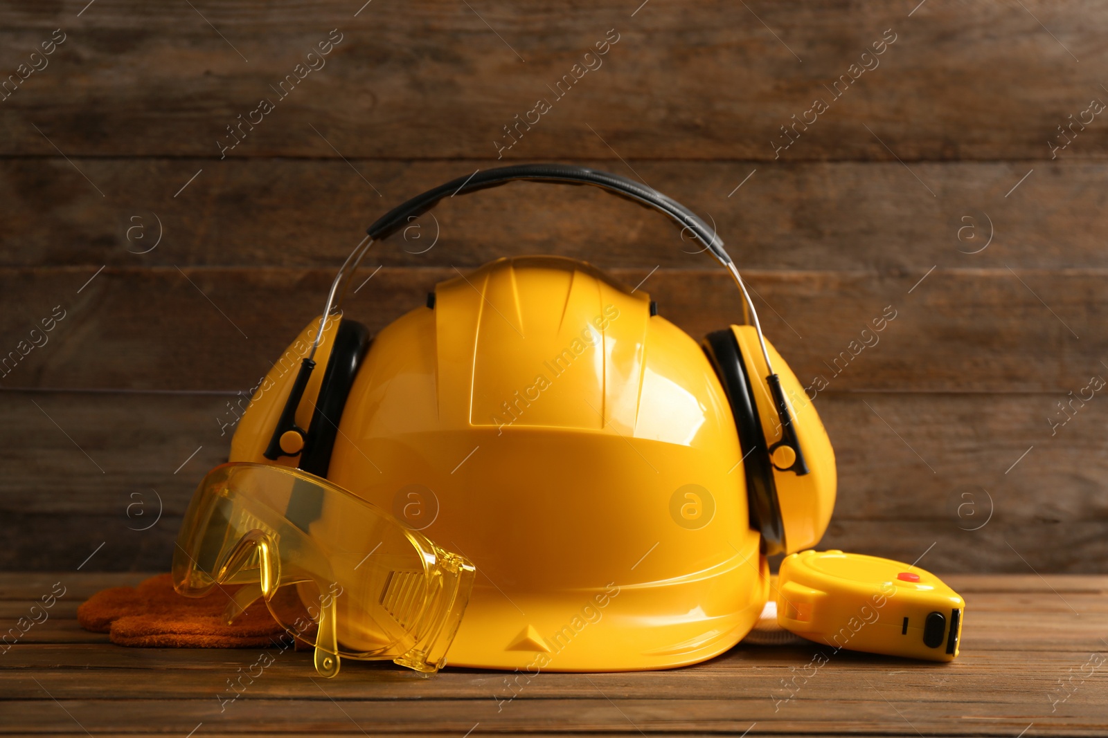 Photo of Composition with measuring tape and safety equipment on wooden table