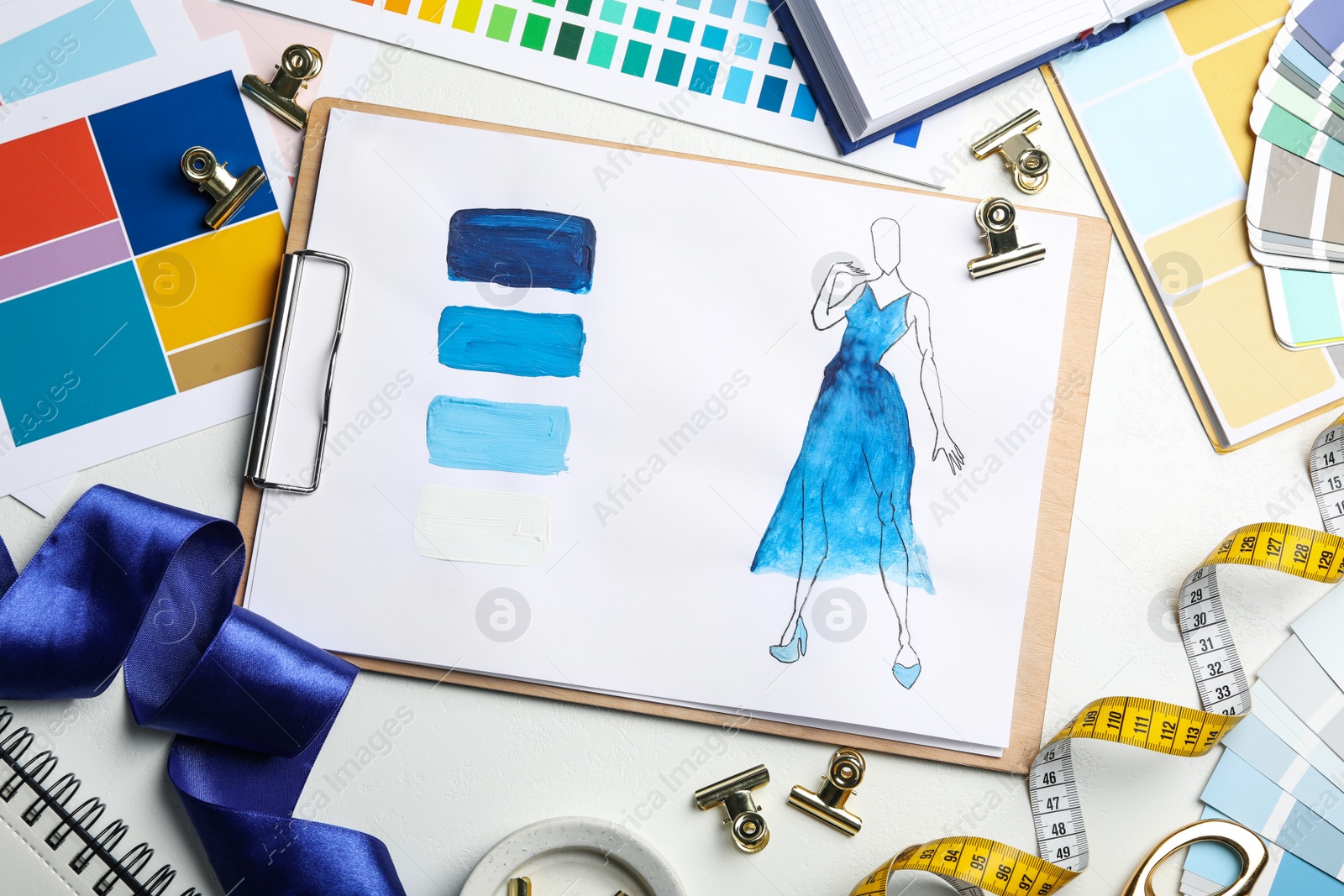 Photo of Flat lay composition with drawing of dress on white table. Designer's workplace