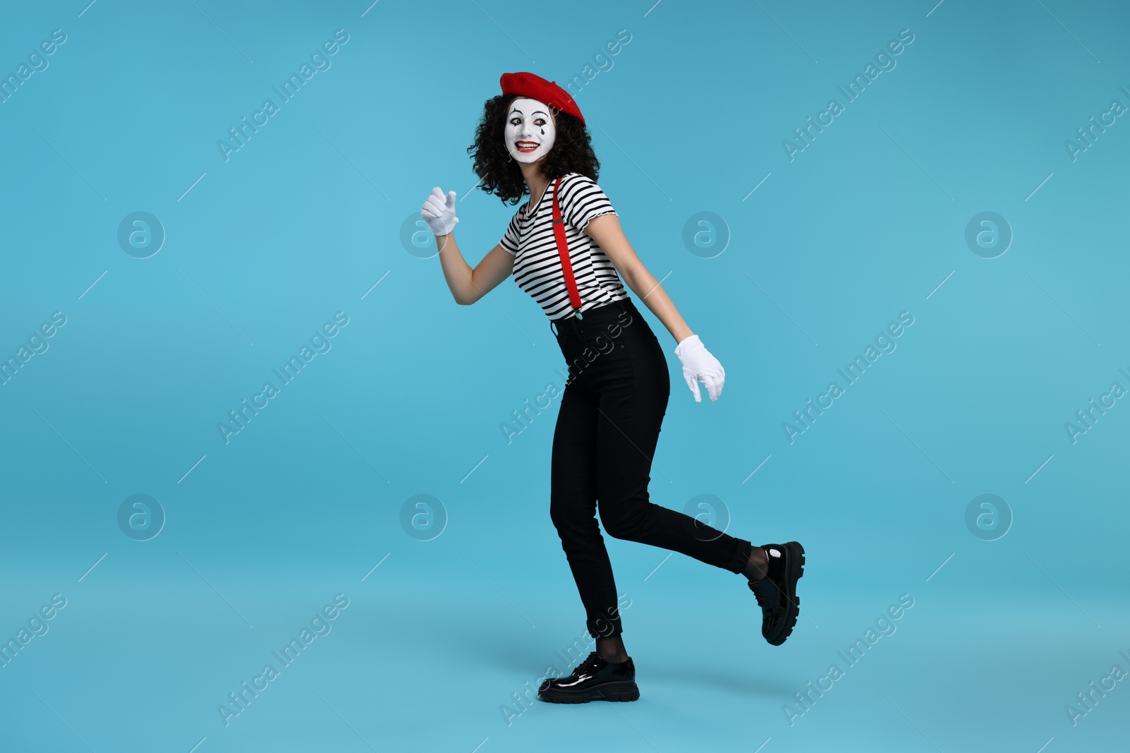 Photo of Funny mime with beret posing on light blue background