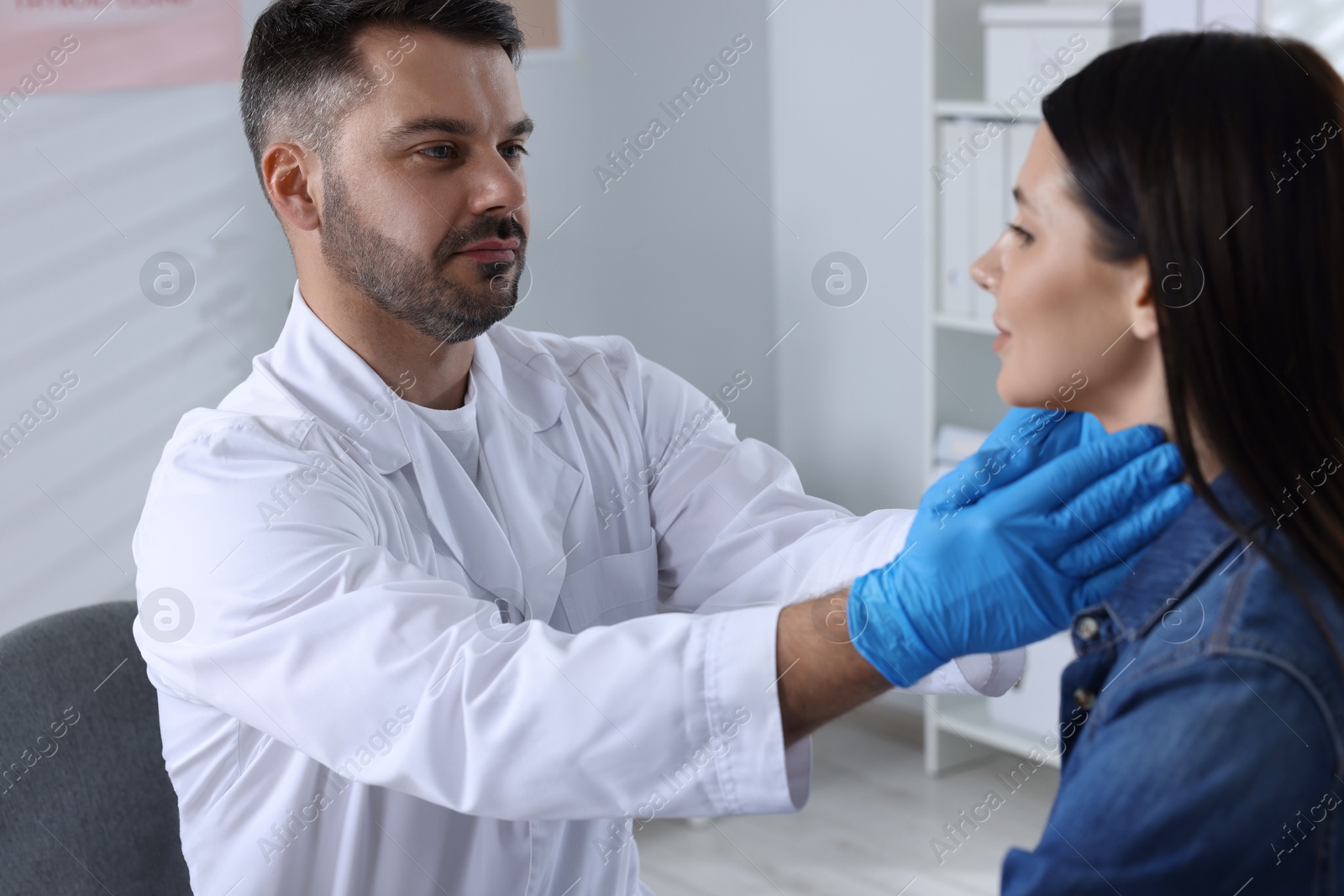 Photo of Endocrinologist examining thyroid gland of patient at hospital