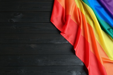 Photo of Bright rainbow gay flag on wooden background, top view with space for text. LGBT community