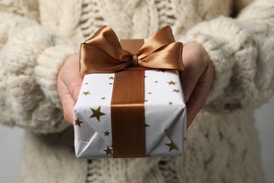 Photo of Woman holding gift box with bow as background, closeup