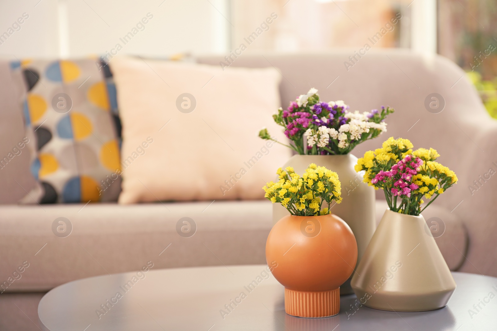 Photo of Beautiful flowers in vases as element of interior design on table. Space for text